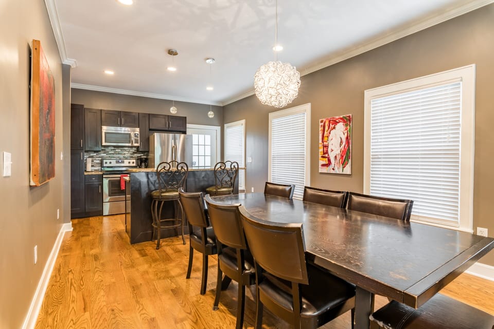 Dining room with 8 seat table and open kitchen with a breakfast bar.
