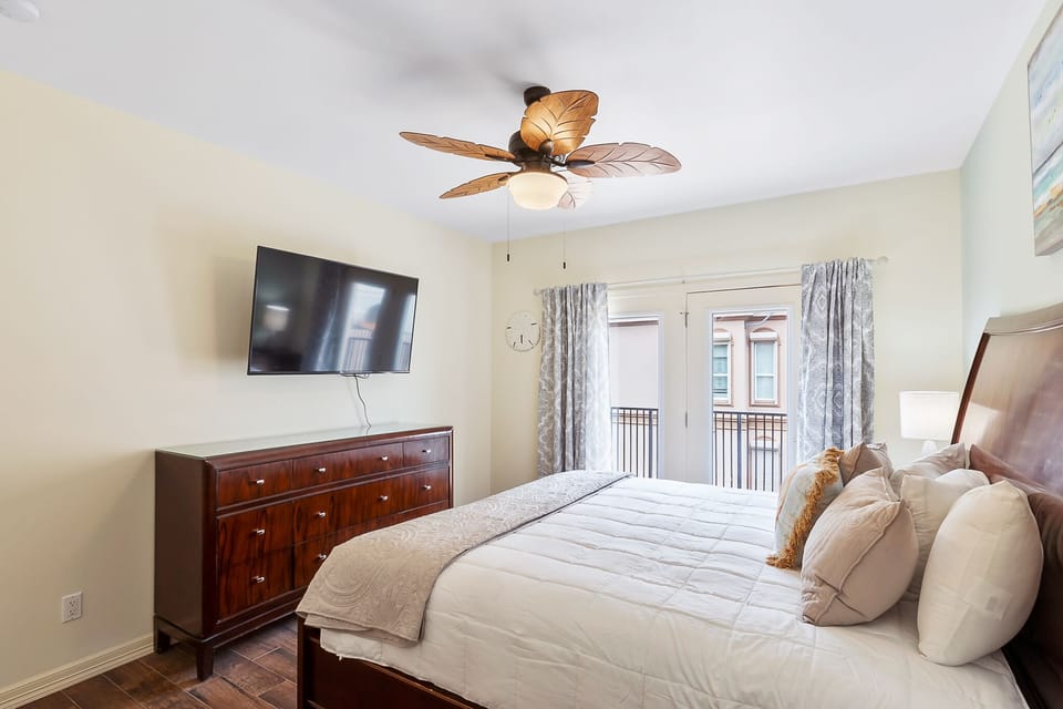Spacious king guest bedroom with TV and natural light