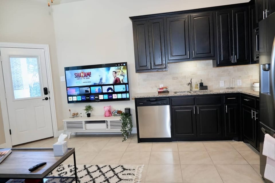 Den with TV and kitchenette wall