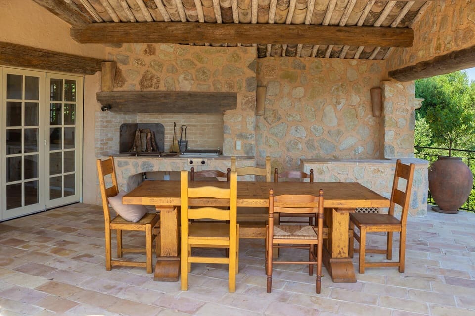 Outdoor dining room next to pool w/ fireplace and BBQ comfortably seats 10.
