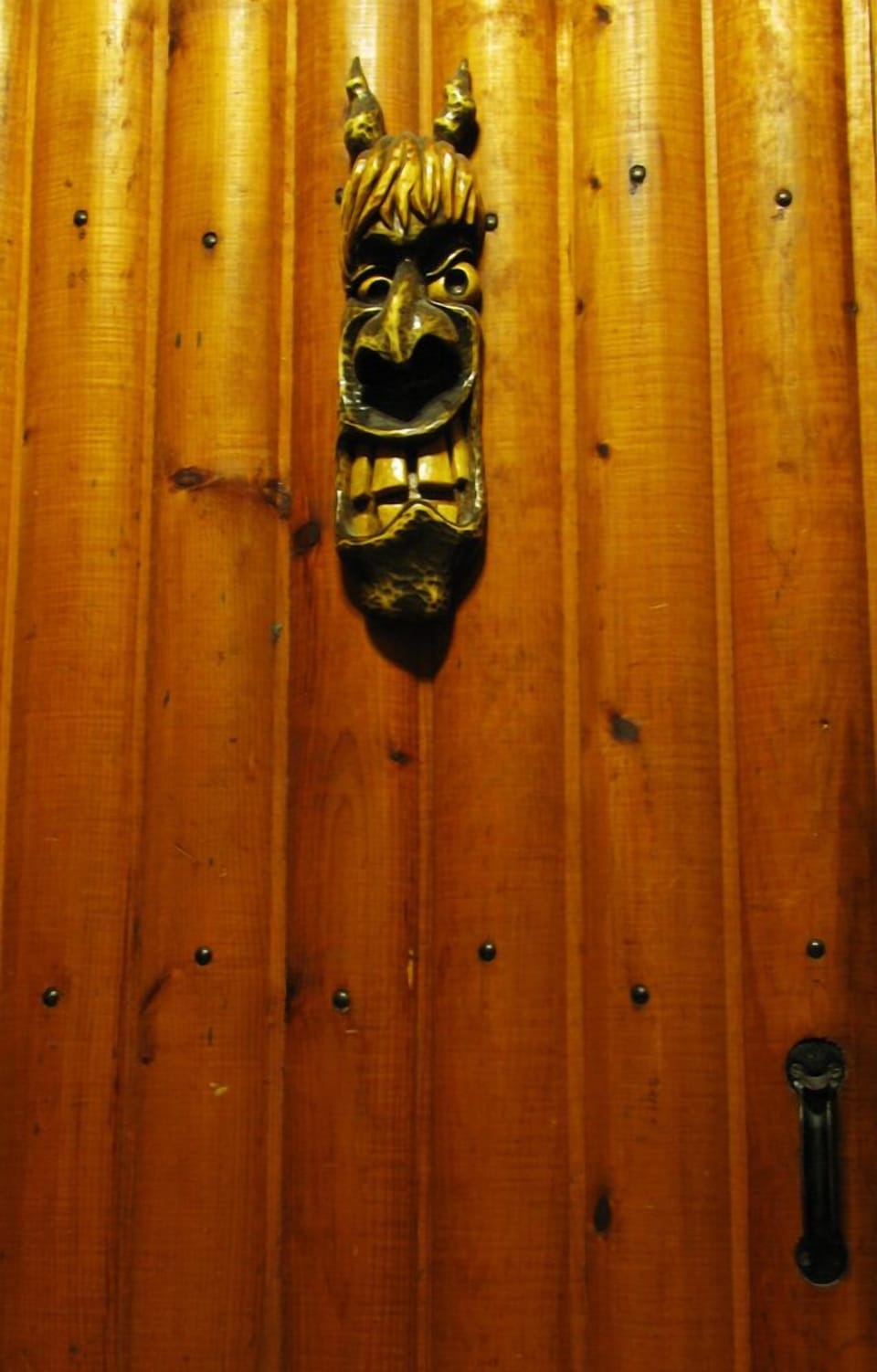 A carving of a mischievous Latvian barn imp graces the interior door.