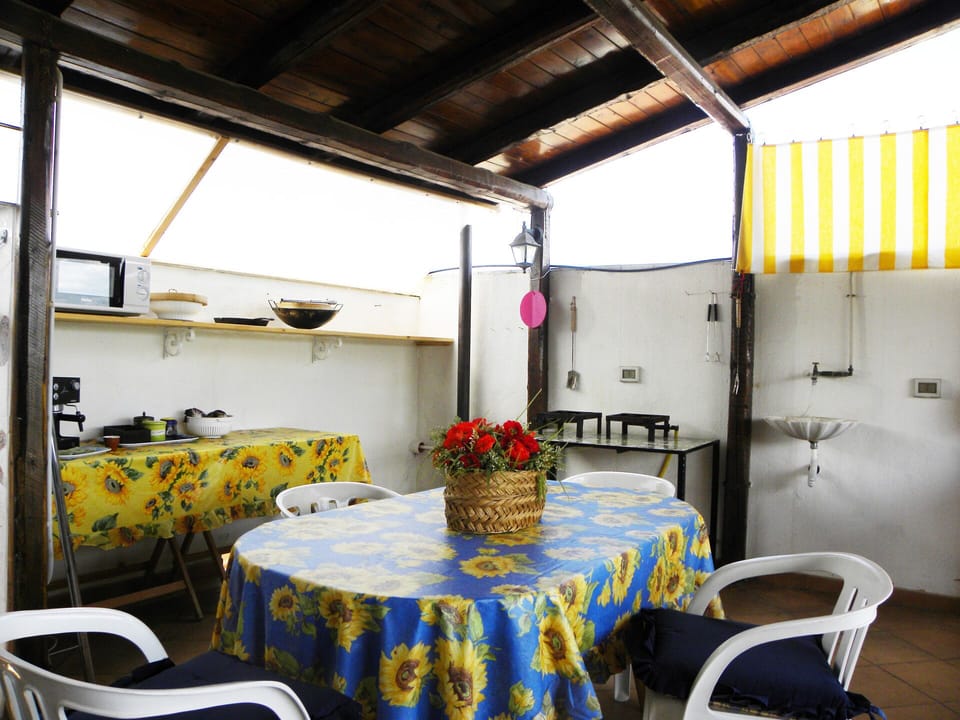 The dining table is next to the cooking and barbeque areas on the main deck