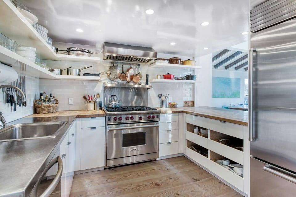 Kitchen with Wolf stove, Sub Zero fridge, pass-through serving area to dining.