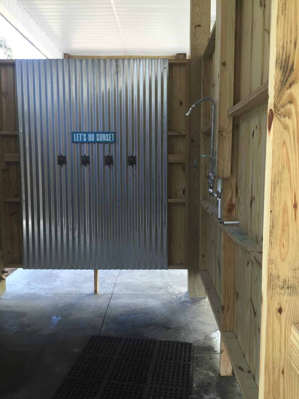 Large outdoor shower with bench area and towel hooks