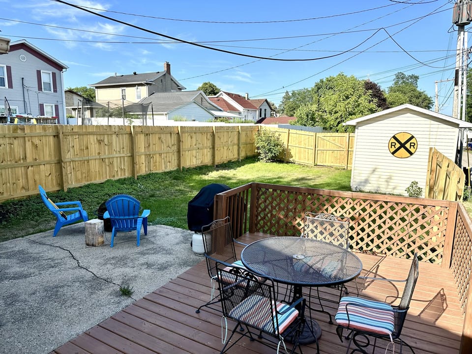 Fully fenced yard with deck, fire pit and grill