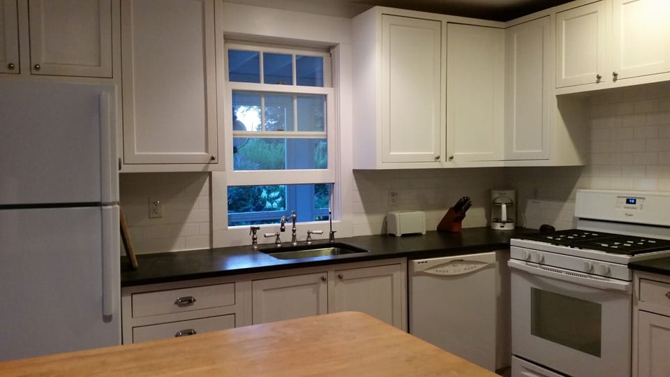 Kitchen with stone countertops, butcher block island, dishwasher and gas stove