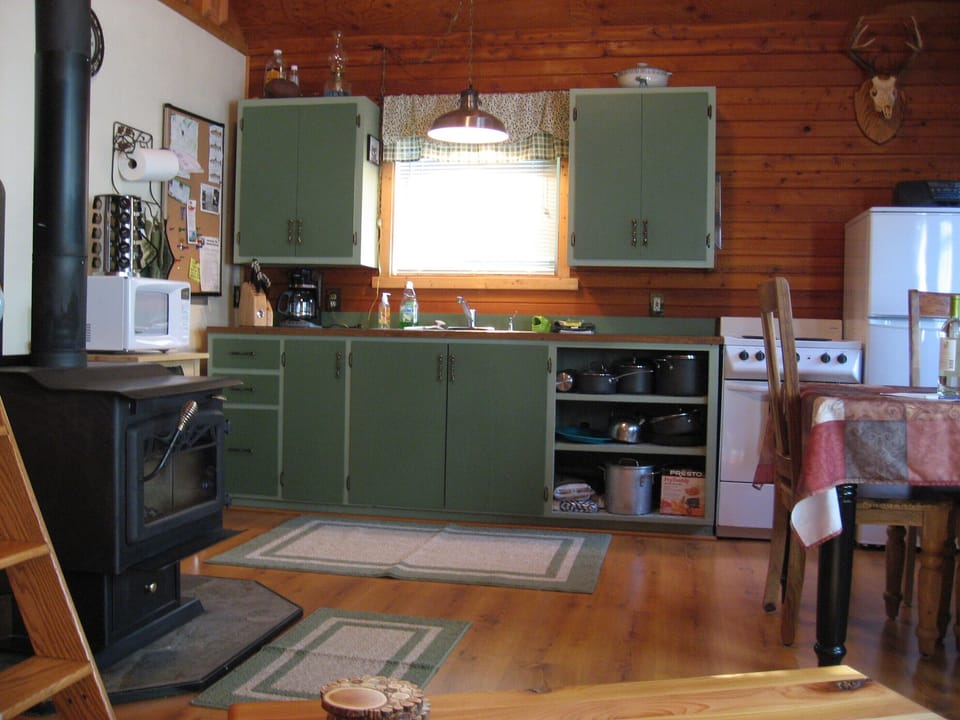 Full Kitchen with microwave, stove, fridge and cooking ware