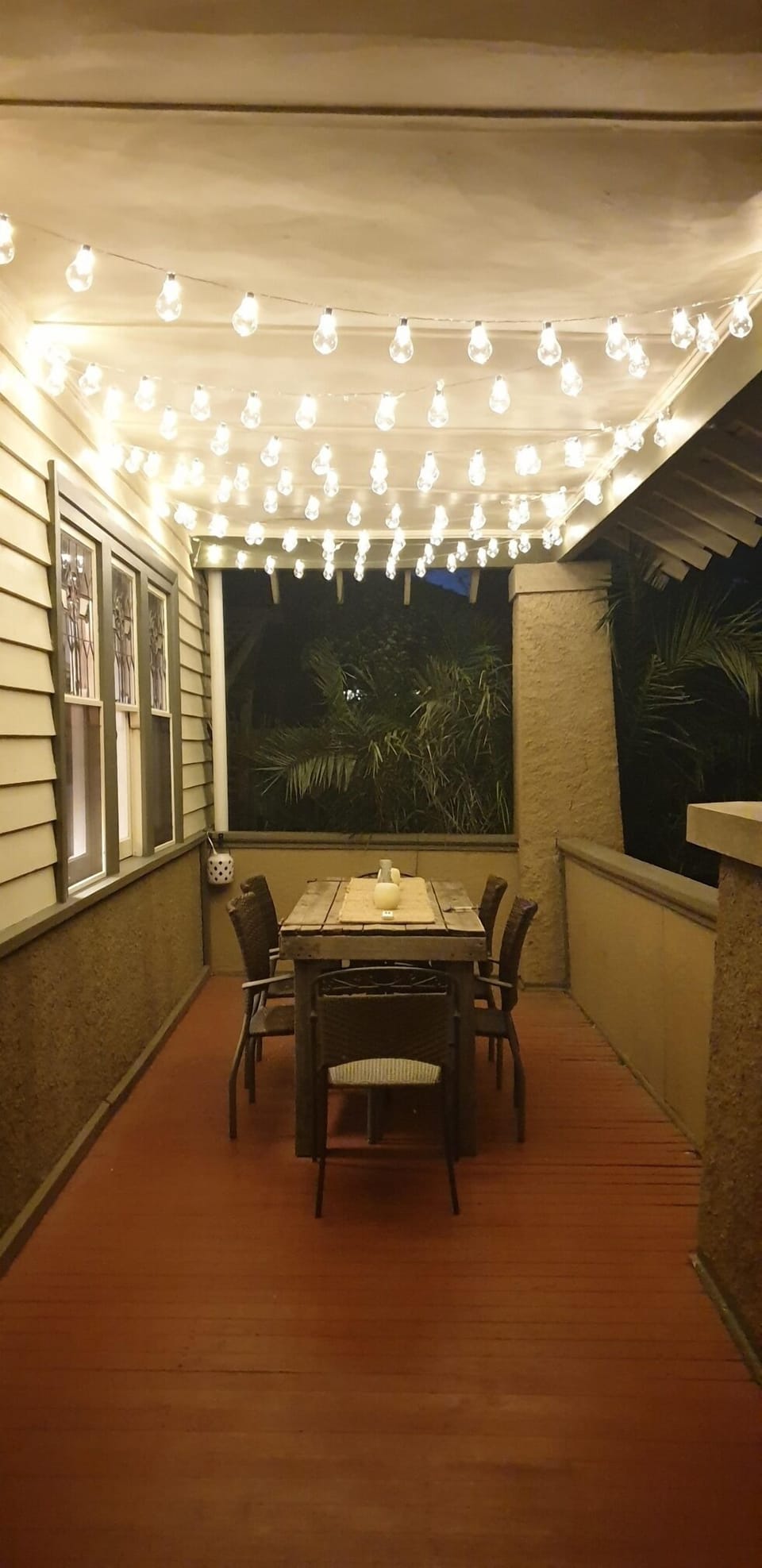 Sitting area on front veranda with fairy lights.