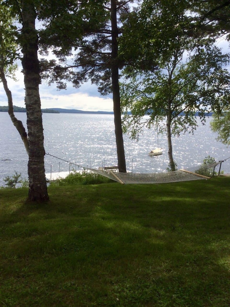 View of Rangeley lake, dock and hammock from front porch of Justawhim.
