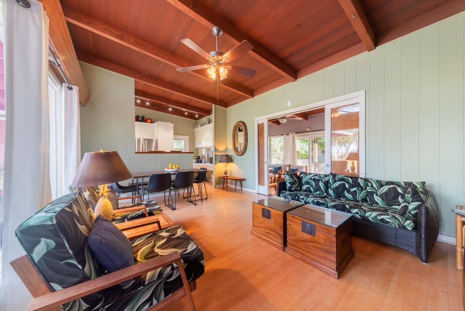 Open living/dining area looking into kitchen and through doors to the lanai