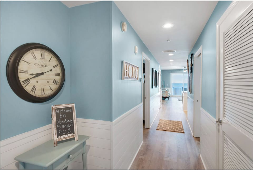 Step into your bright, welcoming hallway where coastal blues meet crisp whites, leading you toward ocean views and comfortable spaces ahead.