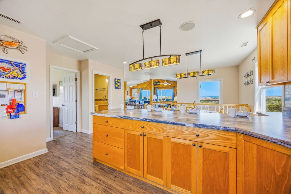 Step into your bright, open kitchen with rich wood cabinetry, granite counters, and sweeping windows framing stunning natural light and horizon views that bring the outdoors right in.