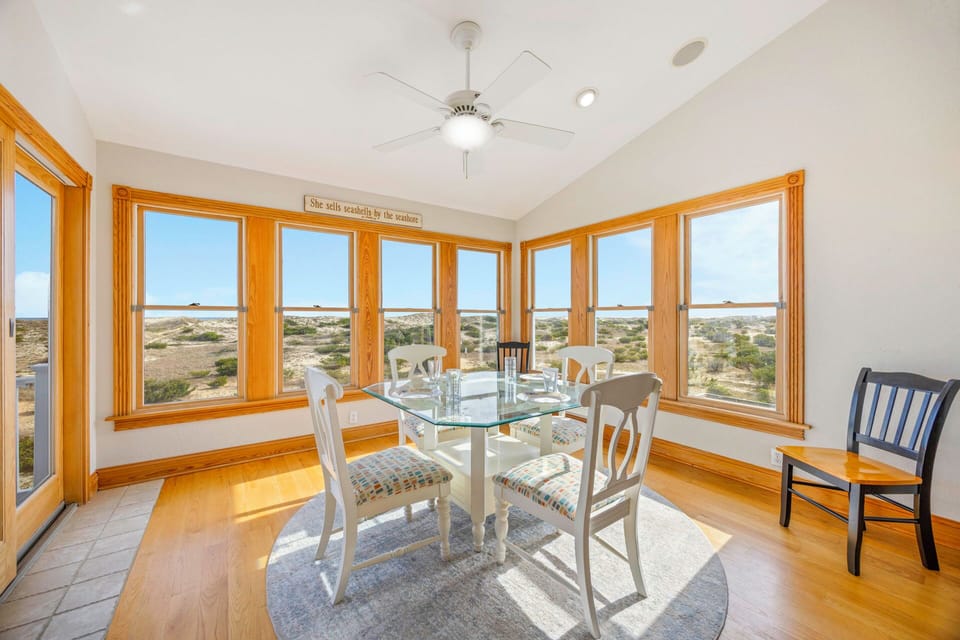 Enjoy meals surrounded by panoramic windows showcasing sweeping natural landscapes in this bright, airy dining space.