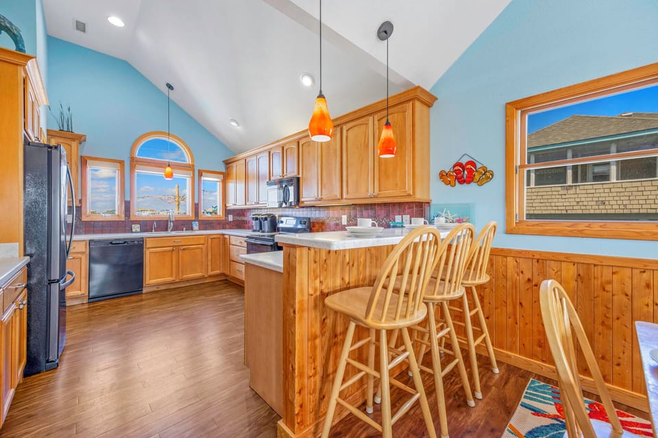 Your spacious kitchen awaits with warm wood cabinetry, granite countertops, and a cozy breakfast bar perfect for morning coffee or evening wine.