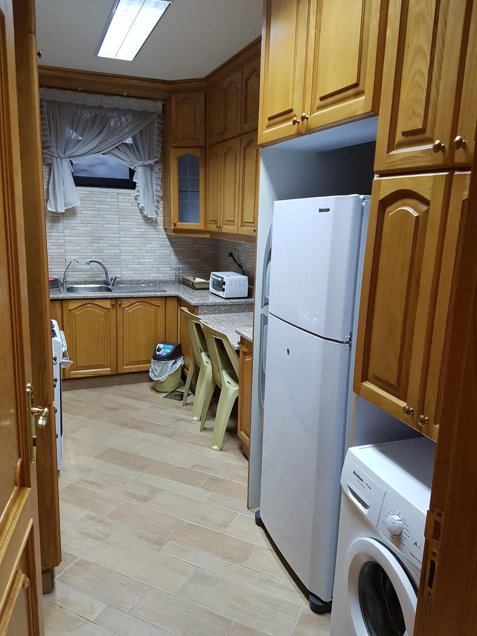 Natural wood kitchen with fridge and washing machine 