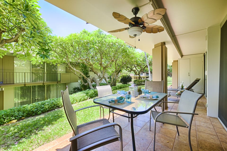Lanai Table & Seating - Outdoor dining table overlooking gardens and tropical greenery.