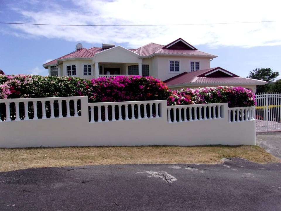 Frontal  view of Rayhope house from with blooming Bougainvillea in foreground