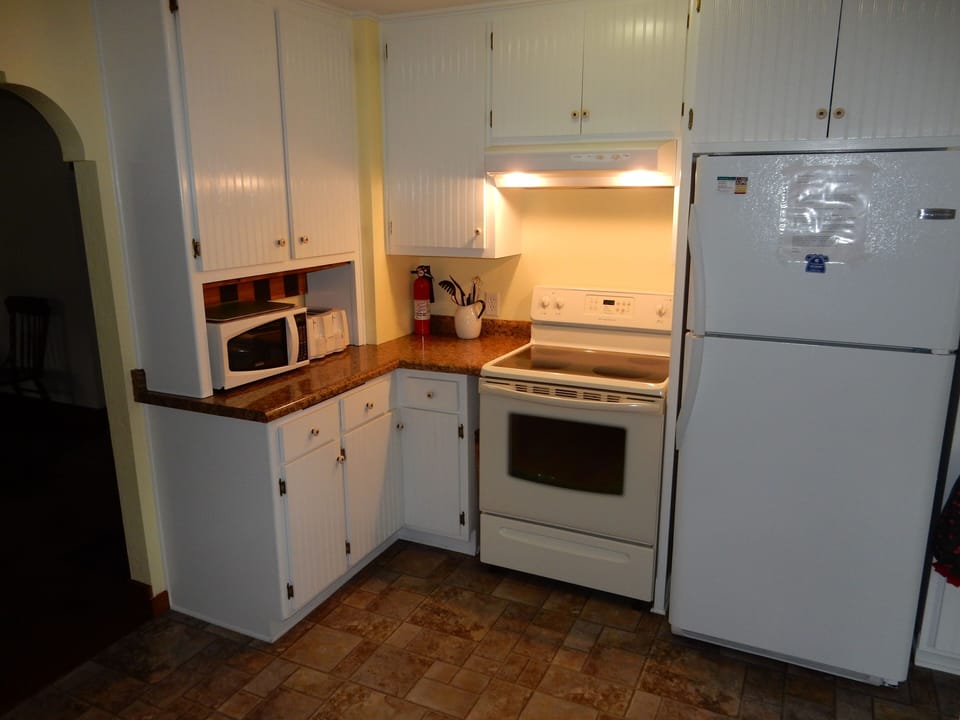 Kitchen, microwave, toaster, refrigerator and a new stove.