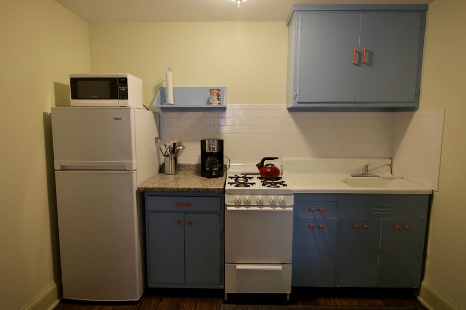 Urban kitchen with gas range, microwave, and efficiency refrigerator.
