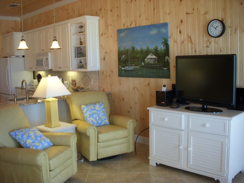 The living room has comfortable seating and a large screen, smart TV w/cable.