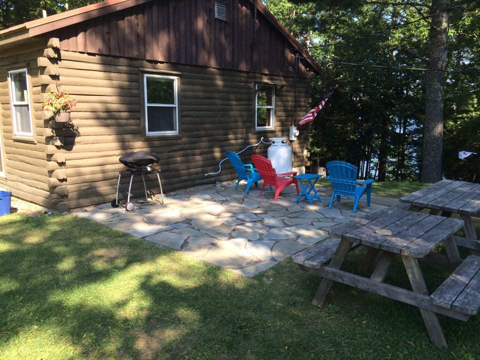 Brand new stone patio for BBQ & hanging out. Lake view through the trees.