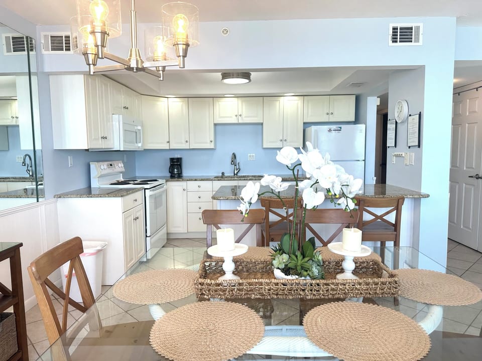Bright kitchen and dining facing ceiling high windows with gulf views