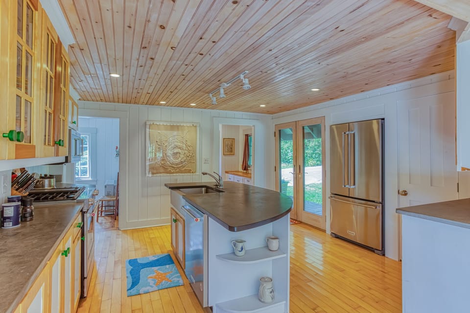 Kitchen view showing center island, door to back porch, bunk room