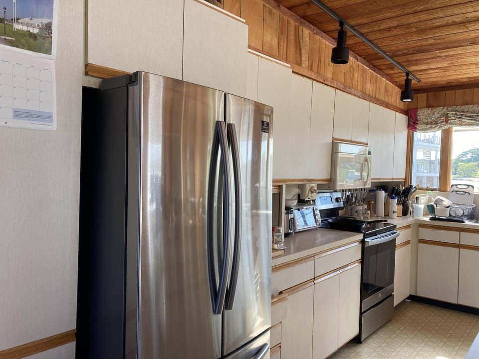 New refrigerator and electric stove, open kitchen with island, bay & pond views