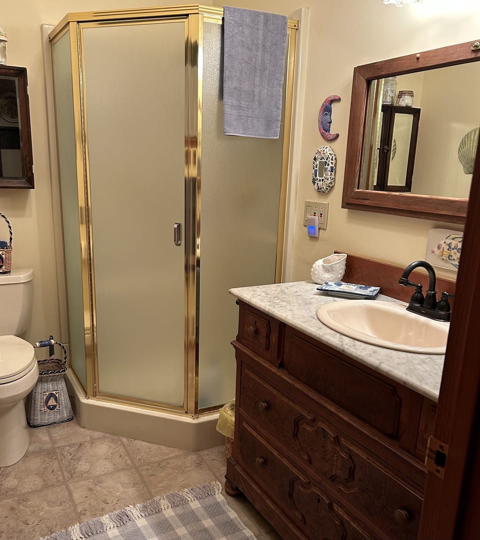 Colorful bathroom with shower and antique vanity.