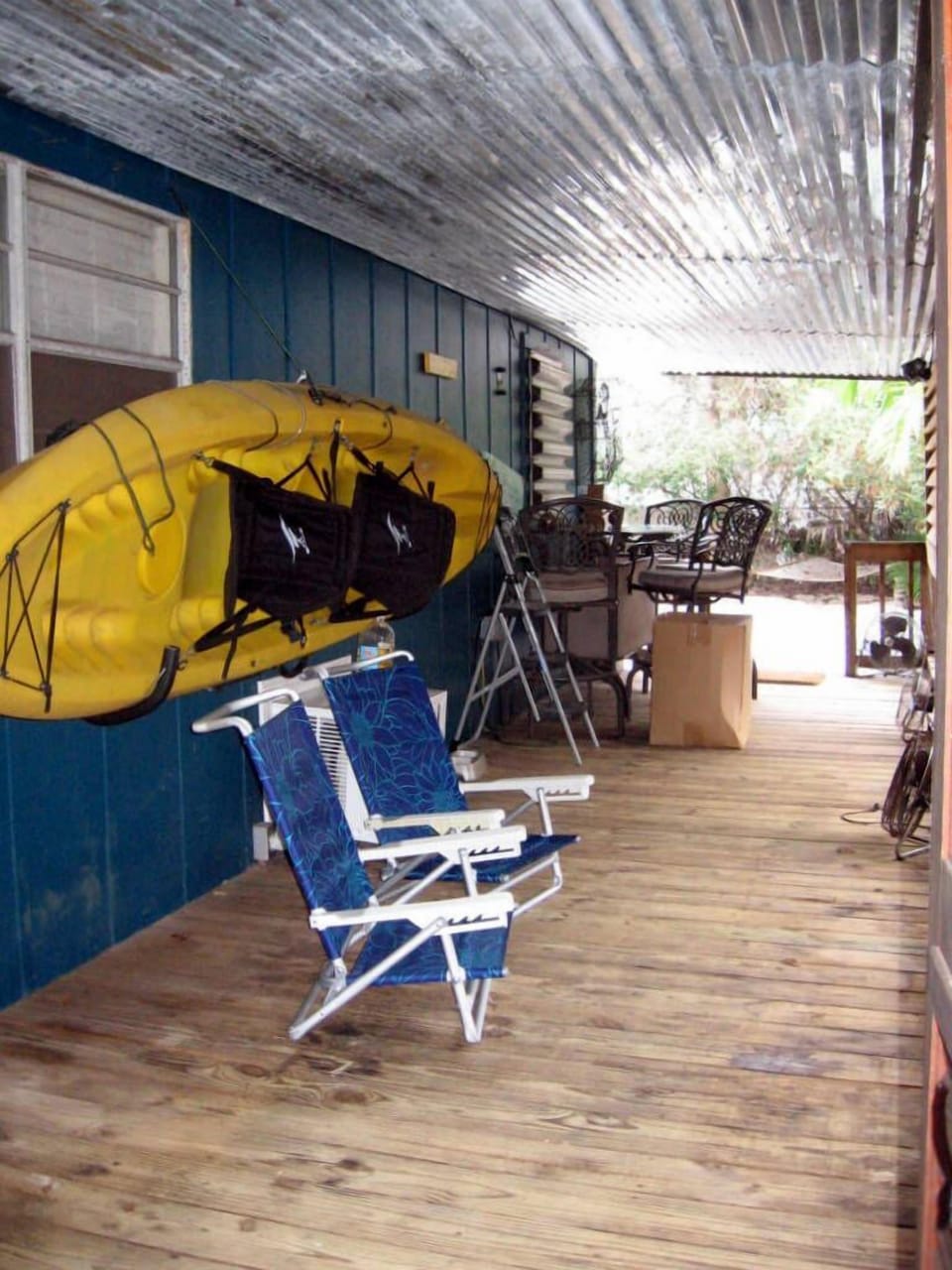 side porch with outdoor seating leading to the back yard and bunkhouse.

