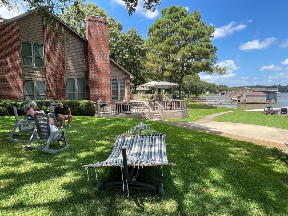 Shaded upper lawn area with hammock and rocking chairs.