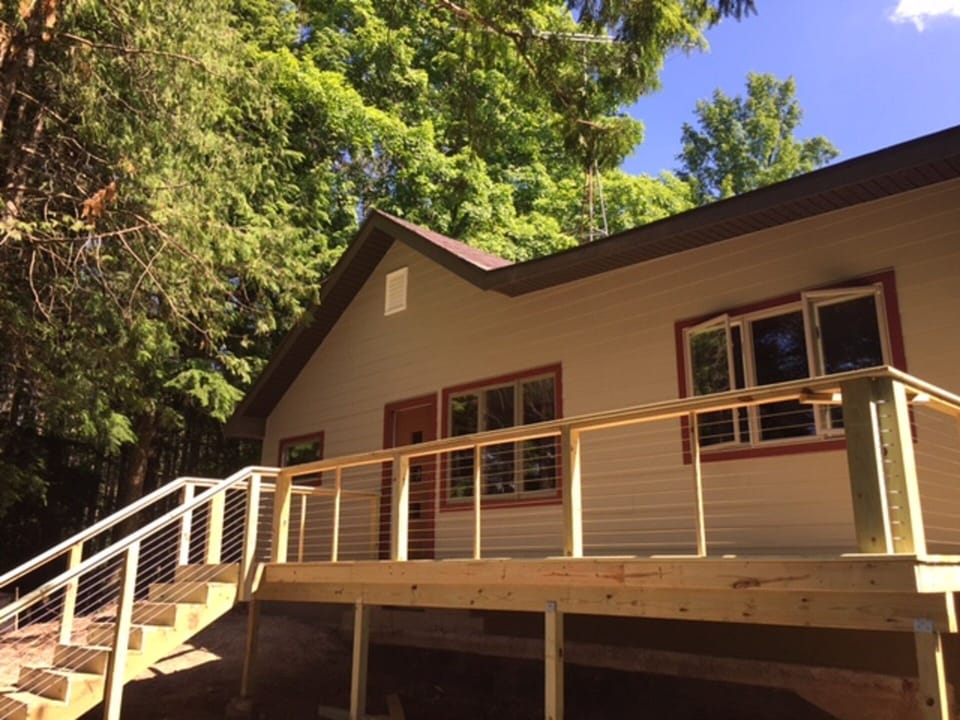 Back of cabin looking out to large backyard/woods and lake