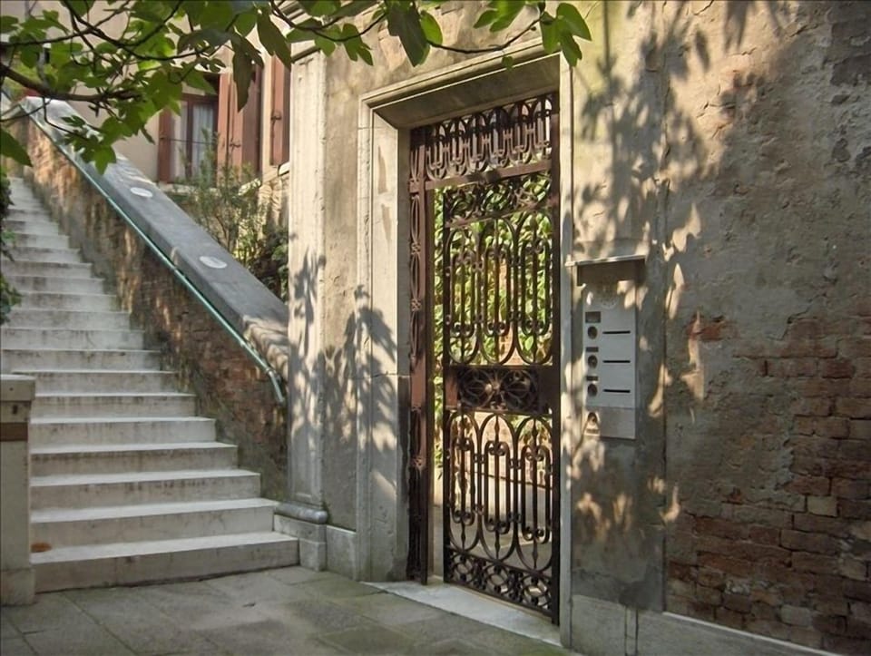 Our entrance gate to the right & bell, neighboring stairs and garden to the left