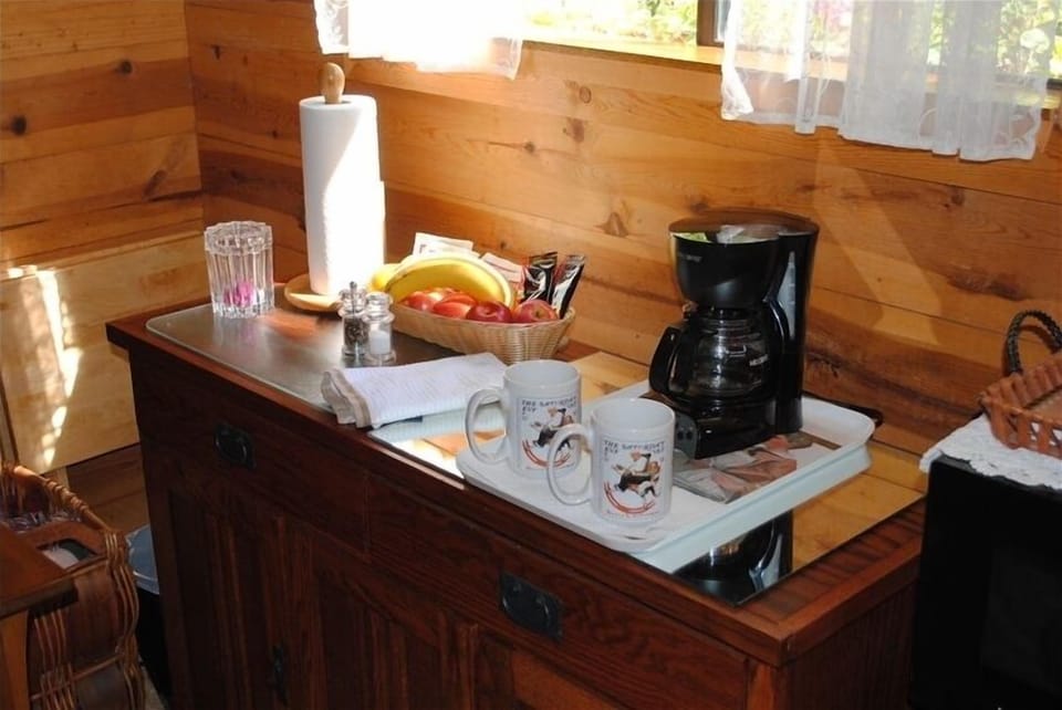 Refreshment area has a refrigerator, microwave, coffee pot, toaster, and dishes.