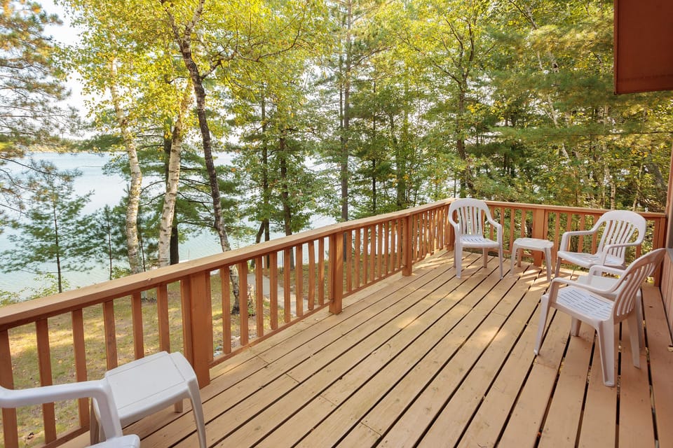 Enjoy the deck overlooking the lake and trees on both sides of the cabin.