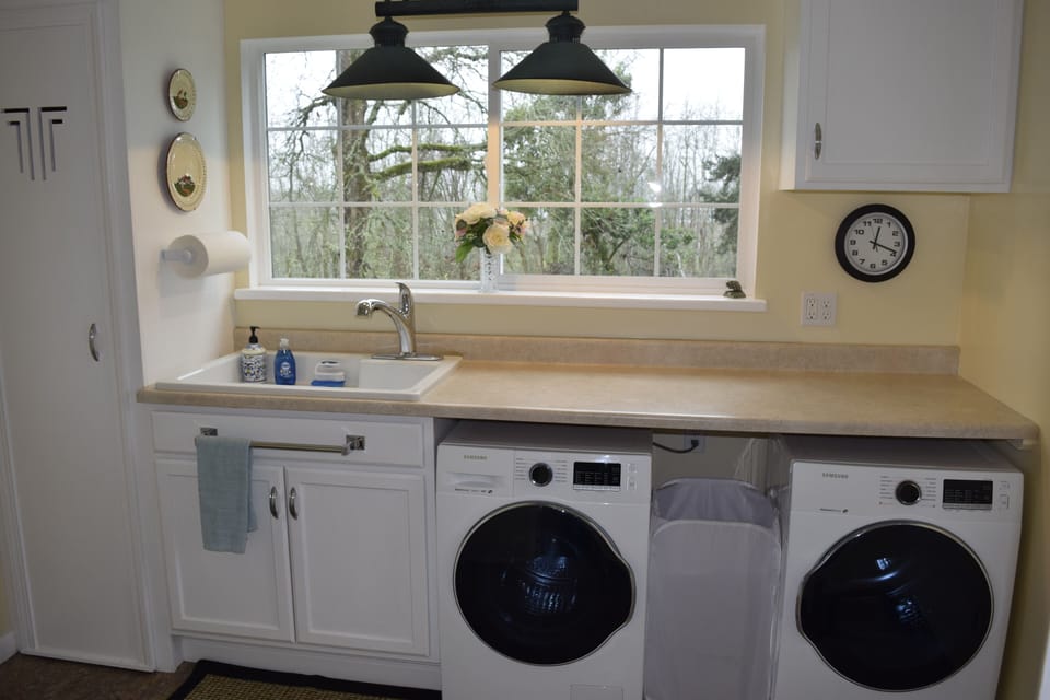 Utility room off kitchen includes washer/dryer, sink, counter space.