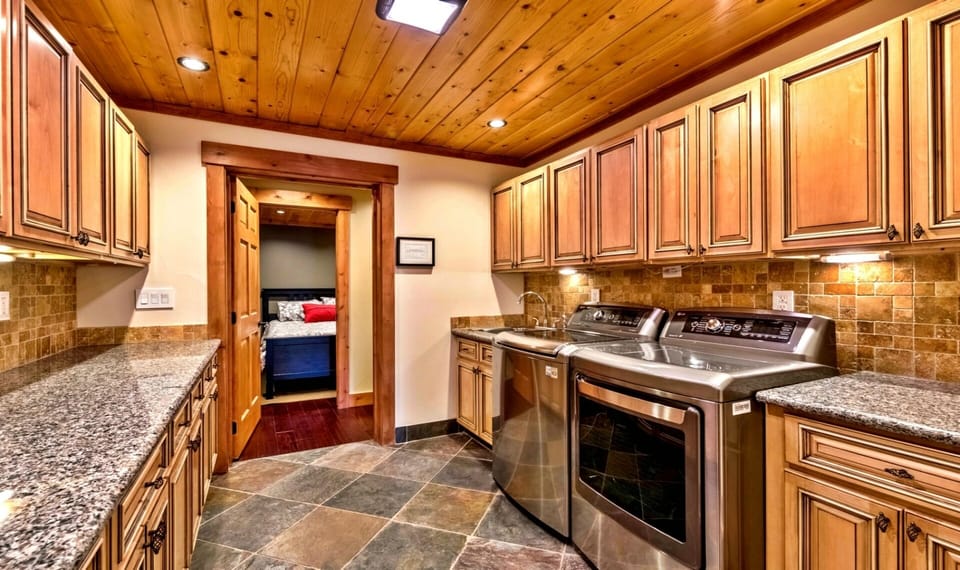 Luxurious and spacious laundry room w/over-sized washer + dryer & granite tops