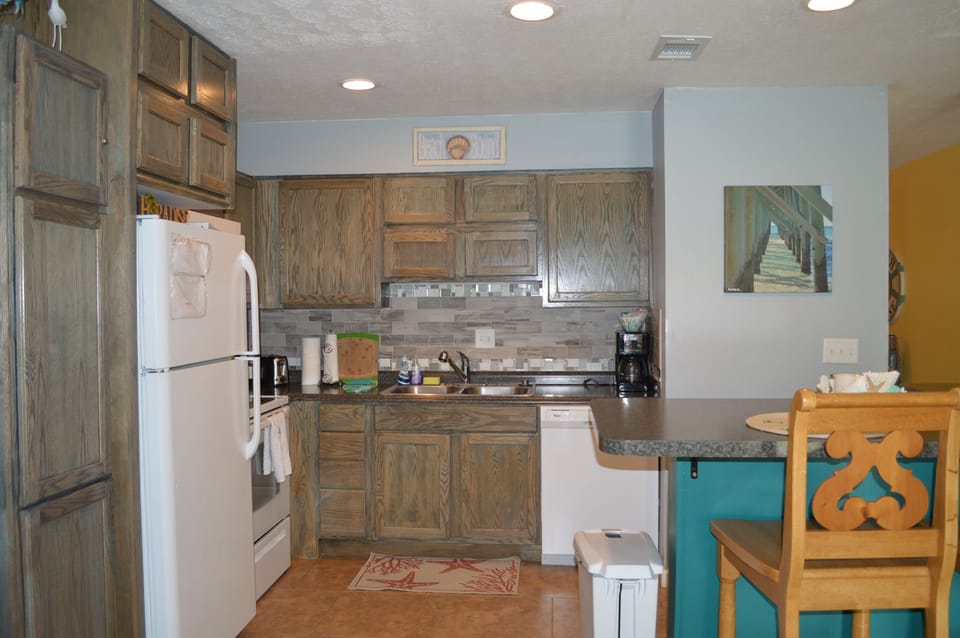 Open kitchen with everything needed for cooking and serving. Lots of cabinets.