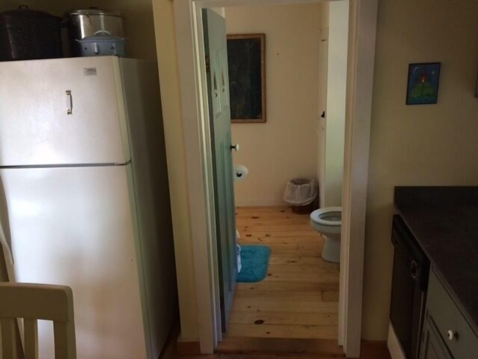 Galley kitchen looking into downstairs bathroom with shower.