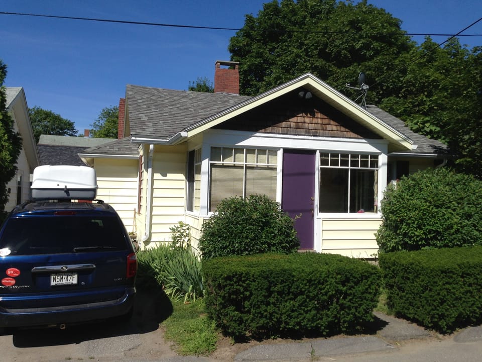 Look for the distinctive purple door! The flower/herb garden are behind the van.