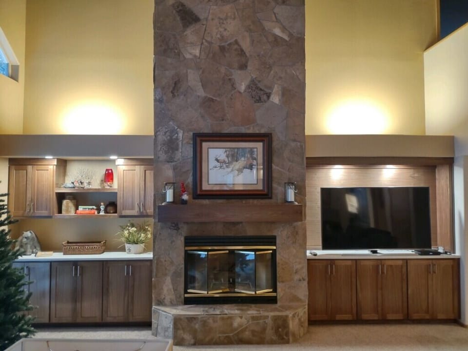 Living area with large smart TV and gas fireplace.
