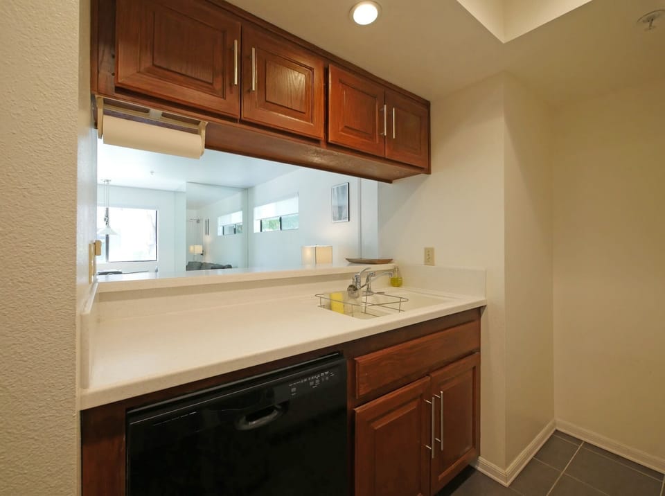 Gorgeous white Corian countertops, charcoal porcelain flooring, new dishwasher