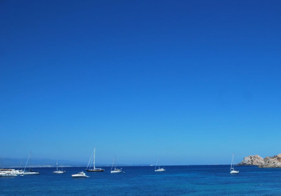 Capo Testa isthmus beach view - Bonifacio's white cliffs visible in the distance