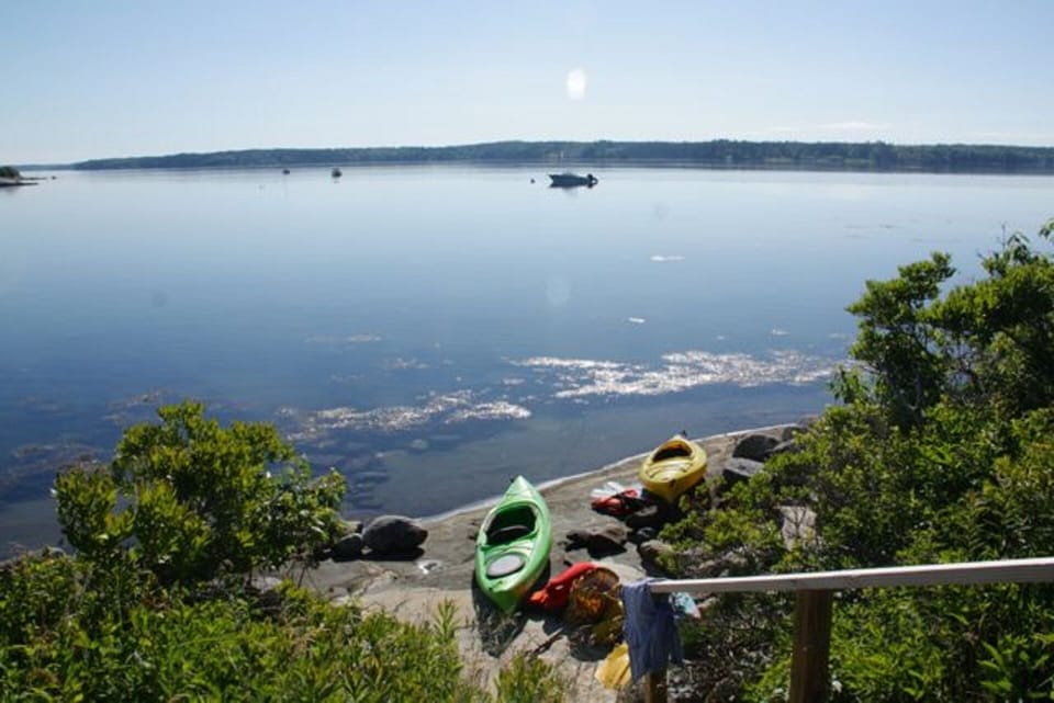 Kayaks on rocks immediately in front of house.