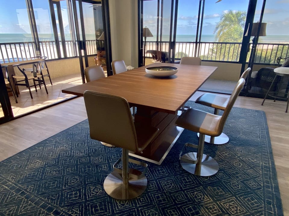 Gorgeous teak/walnut dining. Electronically adjusts from dining to bar height