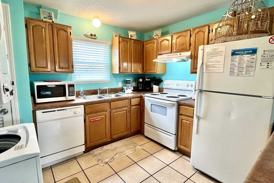 Full kitchen with appliances and stocked with essentials in the cabinets.  A starter pack is provided: roll of pt, mini dish liquid, dishwasher detergent, and laundry packet.