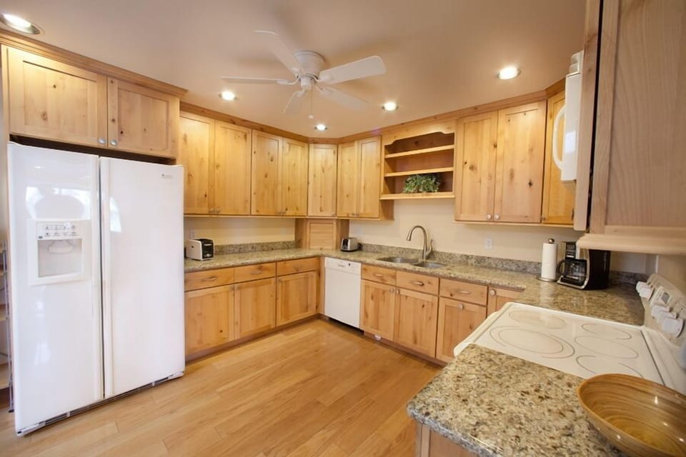 Spacious kitchen with hardwood floors and granite counter tops.