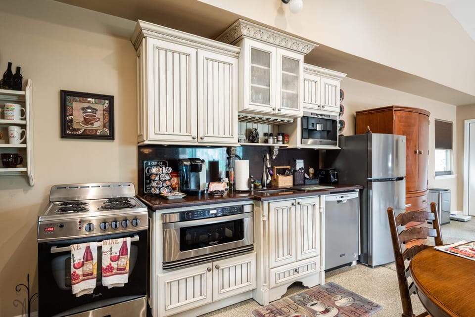 The efficient kitchen has a stocked Keurig, microwave, DW, stove & refrigerator.