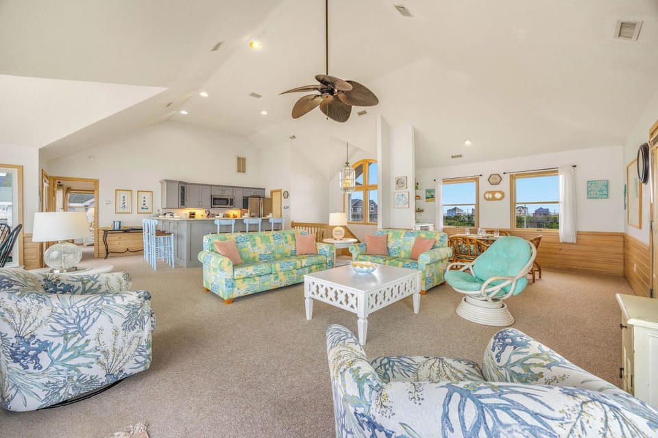 Step into your bright coastal retreat, where vaulted ceilings and tropical breezes create an instantly welcoming escape. Cheerful coastal patterns and plenty of seating invite you to unwind with views of the dunes.