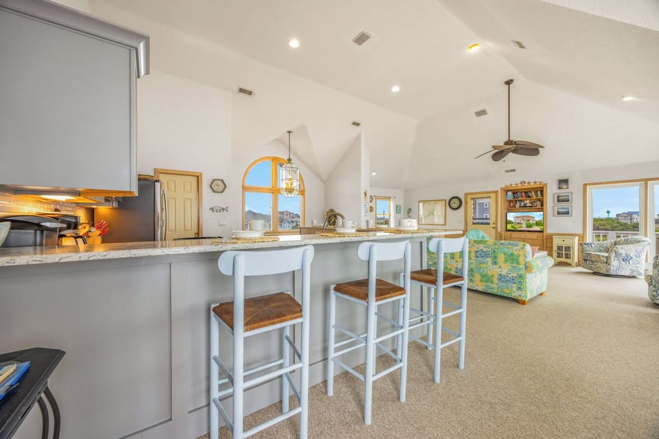 Enjoy this bright, open-concept space where coastal charm meets comfort. Gather around the breakfast bar while sunlight pours through windows, or relax in the airy living area with beachy accents and that perfect vacation vibe.